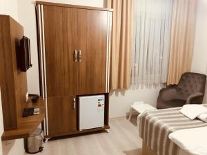 a large wooden cabinet in a room with a bed at Larok Hotel in Akcaabat