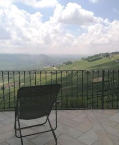 une chaise noire assise sur un balcon avec vue dans l'établissement Sky & Vineyards - Melograno -, à La Morra