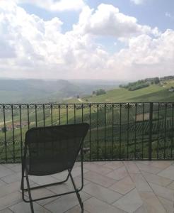 a black chair sitting on a balcony with a view at Sky & Vineyards - Melograno - in La Morra
