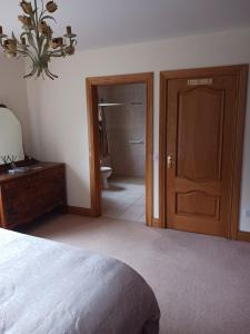 a bedroom with a bed and a bathroom with a toilet at Carraig Ban in Cong