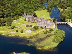 a large castle on an island in the water at Carraig Ban in Cong