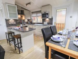 a kitchen with a table and chairs and a counter top at Lavender Lodge in Windermere