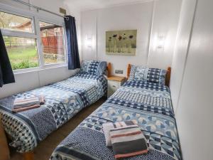 a room with two beds and a window at Lavender Lodge in Windermere