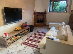 een woonkamer met een bank en een flatscreen-tv bij Chiara House in Barga