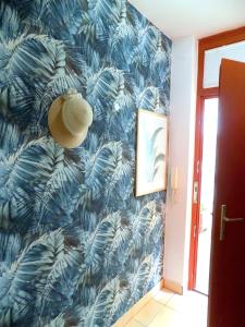 a hallway with a blue wallpaper with a hat on it at Casa Iris in Székesfehérvár