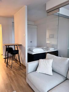 een woonkamer met een bank, een tafel en een bed bij Upouusi luksusasunto! / Areena / Juna-asema /4hlö in Tampere