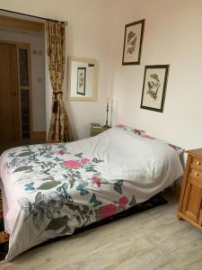 a bedroom with a bed with a floral bedspread at Norfolk broads. Vault apartment in Stalham