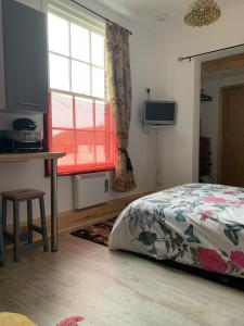 a bedroom with a bed and a window and a table at Norfolk broads. Vault apartment in Stalham