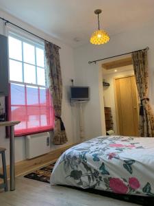 a bedroom with a bed and a window and a television at Norfolk broads. Vault apartment in Stalham