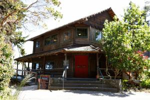 a large wooden house with a red door at Captain Whidbey in Coupeville