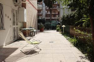 a pair of lawn chairs sitting on a sidewalk at Luminoso e accogliente appartamento con giardino - Battistini in Rome