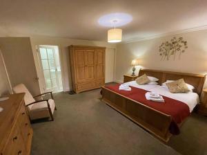 a bedroom with a large bed and a chair in it at The Barn at Rigg End in Rosedale Abbey