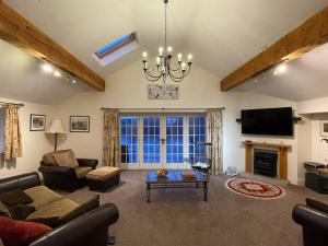 a living room with a couch and a tv at The Barn at Rigg End in Rosedale Abbey