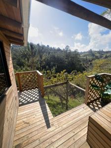 a wooden deck with a view of the mountains at Cardinal Glamping in Guatapé