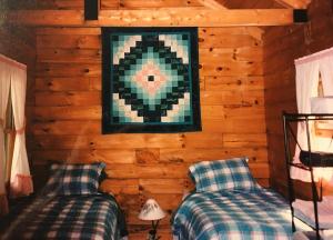 sypialnia z 2 łóżkami i zdjęciem na ścianie w obiekcie Sunset Cottage w mieście Trenton