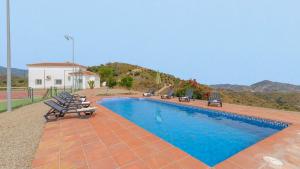 - une piscine avec des chaises et une maison dans l'établissement Villa Bandoleros Arenas by Ruralidays, à Arenas