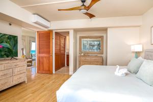 a bedroom with a white bed and a ceiling fan at Welcome to Your Slice of Paradise at Ilikai Hotel in Honolulu