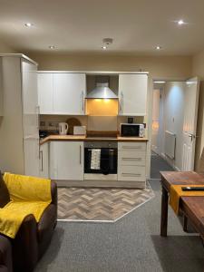 La cuisine est équipée de placards blancs et d'un four avec plaques de cuisson. dans l'établissement COSY 3 - City View, à Sunderland