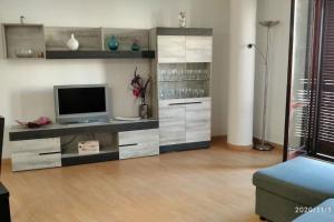a living room with a tv on a cabinet at CASA RO in Tarragona +3 photos