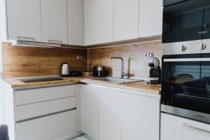 a white kitchen with a sink and a microwave at Faros Flat in Alexandroupoli