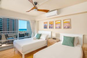 a bedroom with two beds and a balcony at Welcome to Your Slice of Paradise at Ilikai Hotel in Honolulu