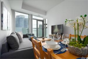 a living room with a couch and a table with wine glasses at Stunning 1+Den Condo, Breathtaking Views in Toronto