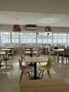 jadalnia ze stołami, krzesłami i oknami w obiekcie Columbia Palace Hotel w BuenosAires