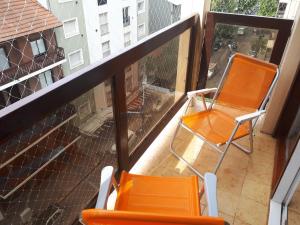 two orange chairs sitting on a balcony at Mar del Plata 2 ambientes en La Perla in Mar del Plata