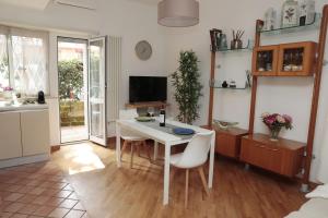 a kitchen and dining room with a white table and chairs at Luminoso e accogliente appartamento con giardino - Battistini in Rome