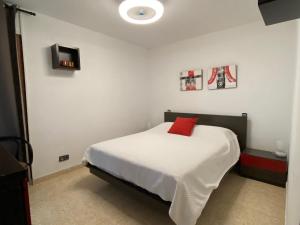a bedroom with a bed with a red pillow on it at Playa Esquirol in Cambrils +16 photos