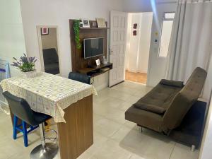 een woonkamer met een tafel en een stoel bij Apartamento Floripa 16 - Próximo Ao Centro, UFSC, Aeroporto e Praias in Florianópolis