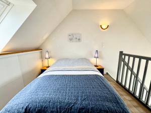 Schlafzimmer mit einem Bett mit blauer Decke in der Unterkunft Charmant T3 duplex 2 Bord de mer Terrasse in Quiberon