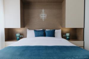 um quarto com uma grande cama branca com almofadas azuis em Faros Flat em Alexandroupoli