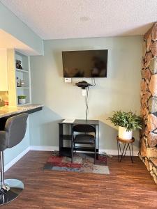 a desk with a chair and a television on a wall at Bearadise Retreat At English Mountain Condo in Sevierville