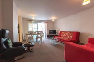 a living room with a red couch and a table at Accessible 2 bedrooms flat + P in Southampton