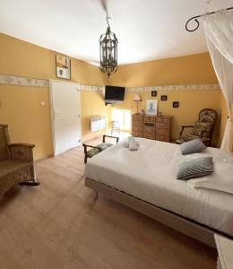 ein Schlafzimmer mit einem großen Bett und einem Kronleuchter in der Unterkunft La Villa de la Chapinière in Châteauvieux