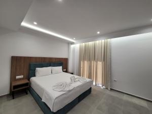 a bedroom with a large bed and a window at Prestige Hotel in Ksamil