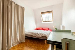 a bedroom with a bed with red pillows on it at Chbre 2P + navette CDG in Aulnay-sous-Bois