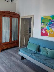 ein Wohnzimmer mit einem blauen Sofa und einem Schrank in der Unterkunft Artesia - Junior Suite in Angellara