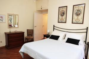 a bedroom with a large white bed and a mirror at Luminoso e accogliente appartamento con giardino - Battistini in Rome