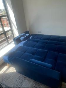 a blue couch in a room with a window at Modern Stylish Apartment in Birmingham in West Bromwich