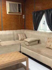 un sofá blanco en una sala de estar con ventana en شاليه نزل أمنة en Sīdī Ḩamzah