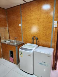 uma cozinha com um lavatório e uma máquina de lavar roupa em شاليه نزل أمنة em Sīdī Ḩamzah