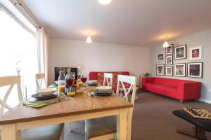 a dining room with a table and a red couch at Accessible 2 bedrooms flat + P in Southampton