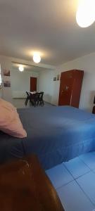 a bedroom with a blue bed and a table at Cafaro in San Miguel de Tucumán