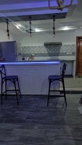 - deux chaises devant un bar dans la cuisine dans l'établissement All seasons holiday, à El Haouaria