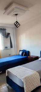 um quarto com um sofá azul e uma cama azul em All seasons holiday em El Haouaria