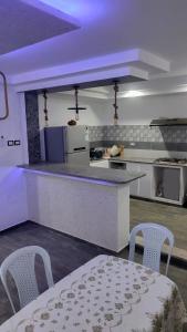 una cucina con tavolo, sedie e piano di lavoro di All seasons holiday a El Haouaria