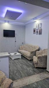 - un salon avec deux canapés et une télévision dans l'établissement All seasons holiday, à El Haouaria