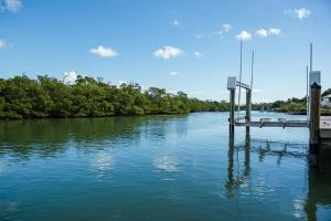 a river with a dock in the middle of it at Waterfront Pink House with Private Dock & Pool in Captiva